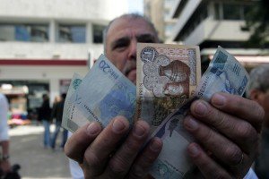Ein Mann zeigt Euro-Scheine und Zypern-Pfund (bis zum 31. Dezember 2007 die Währung auf Zypern). Foto: dpa