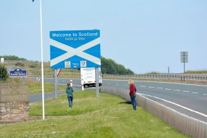 Ein Schild mit der Aufschrift "Willkommen in Schottland" steht auf einem Parkplatz der A1 an der englisch-schottischen Grenze in der Nähe von Berwick-upon-Tweed.  Foto: dpa