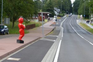 Wer über den Grenzübergang Köpfchen (im Hintergrund) nach Belgien einreist, kann den roten Knaben mit der Tüte Fritten in der Hand nicht übersehen. Foto: OD