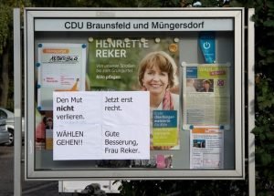Auf einer Informationstafel am Wochenmarkt in Köln-Braunsfeld wurden nach dem Anschlag von Mitte Oktober Zettel mit Aufschriften "Den Mut nicht verlieren", "Wählen gehen", "Jetzt erst recht" und "Gute Besserung, Frau Reker" angebracht. Foto: dpa